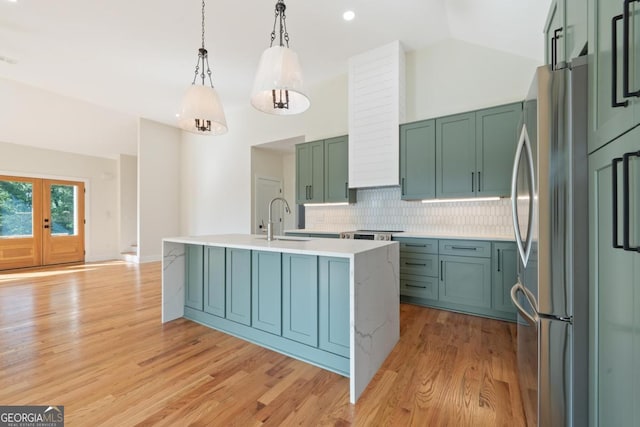631 Susan Davis Rd, Sparta, GA 31087 - kitchen with freestanding refrigerator, vaulted ceiling, an island with sink, light countertops, and decorative backsplash