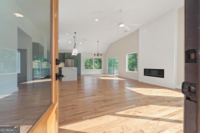 631 Susan Davis Rd, Sparta, GA 31087 - unfurnished living room with wood finished floors, a fireplace, a ceiling fan, recessed lighting, and high vaulted ceiling