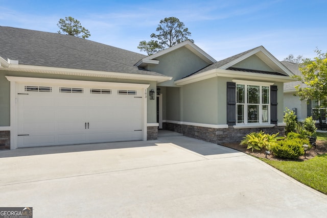 183 Ryan Nicholas Dr, Kingsland, GA 31548 - view of front of home with stone siding, a garage, concrete driveway, roof with shingles, and stucco siding
