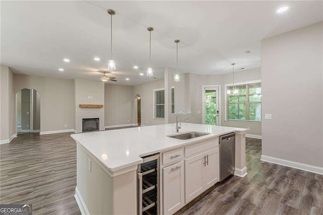 150 Whitworth Dr, Locust Grove, GA 30248 - kitchen featuring beverage cooler, dishwasher, a fireplace, dark wood-style flooring, and a kitchen island with sink