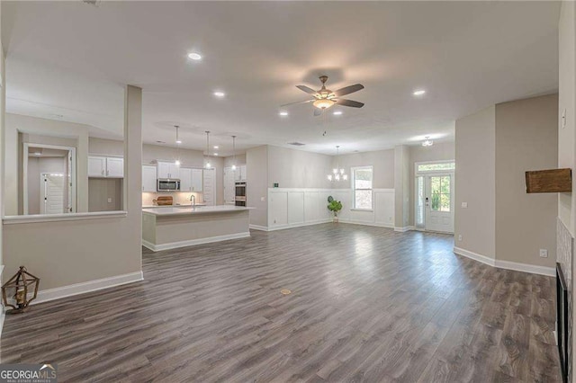 150 Whitworth Dr, Locust Grove, GA 30248 - unfurnished living room with a ceiling fan, recessed lighting, dark wood-style floors, and a chandelier