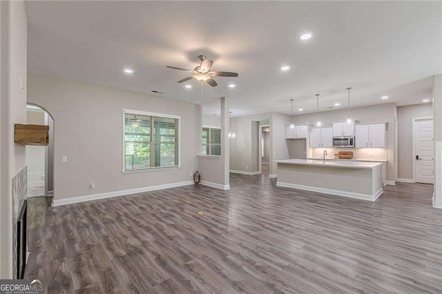 150 Whitworth Dr, Locust Grove, GA 30248 - unfurnished living room featuring a ceiling fan, dark wood-style flooring, recessed lighting, and arched walkways