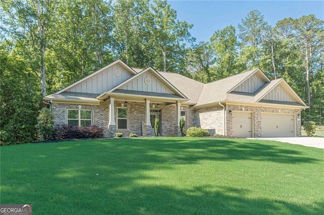150 Whitworth Dr, Locust Grove, GA 30248 - craftsman-style house with board and batten siding, a front lawn, a garage, and brick siding