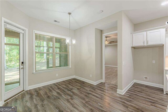150 Whitworth Dr, Locust Grove, GA 30248 - unfurnished dining area featuring dark wood-style flooring, a chandelier, and a ceiling fan