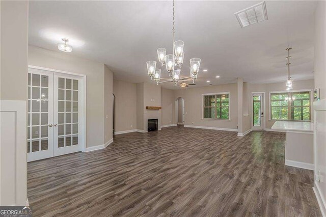 150 Whitworth Dr, Locust Grove, GA 30248 - unfurnished living room with french doors, dark wood-style floors, a chandelier, arched walkways, and recessed lighting
