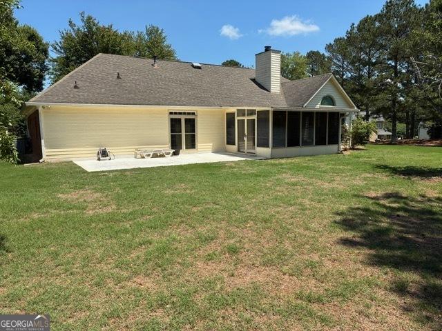 9361 Arbor Glenn Ct, Jonesboro, GA 30263 - back of house featuring a patio, a sunroom, a yard, a chimney, and roof with shingles