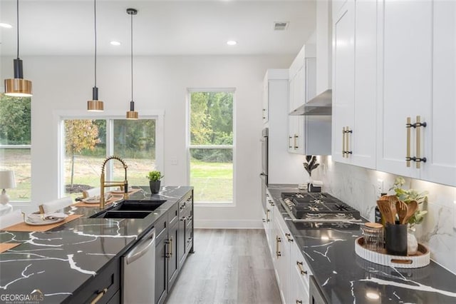 2312 Herring, Atlanta, GA 30311 - kitchen featuring dishwashing machine, stainless steel gas cooktop, light wood-type flooring, white cabinets, and dark stone countertops