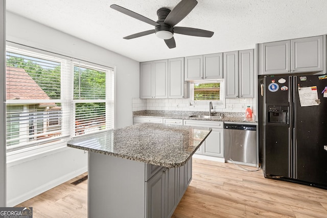 936 Tyrell Dr, Austell, GA 30106 - kitchen featuring black fridge, stainless steel dishwasher, gray cabinets, light wood-style floors, and a ceiling fan