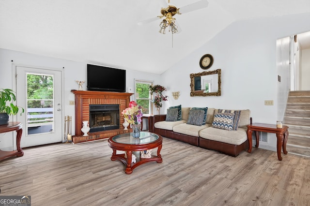 936 Tyrell Dr, Austell, GA 30106 - living room featuring lofted ceiling, ceiling fan, wood finished floors, stairway, and a brick fireplace