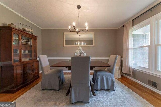 160 Edgewood Dr, Athens, GA 30606 - dining space with a chandelier, light wood-type flooring, and crown molding