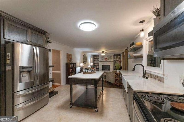 160 Edgewood Dr, Athens, GA 30606 - kitchen featuring stainless steel appliances, a large fireplace, a ceiling fan, light countertops, and dark brown cabinetry
