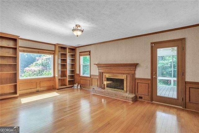 2830 Scottish Mill Way, Marietta, GA 30068 - unfurnished living room with wood-type flooring, built in shelves, ornamental molding, a textured ceiling, and a fireplace