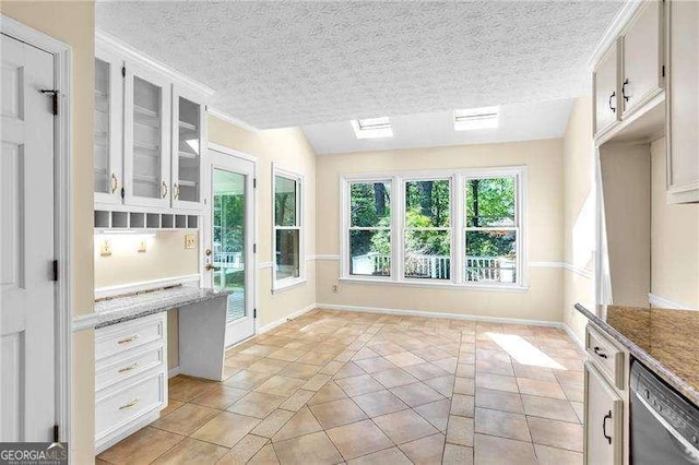 2830 Scottish Mill Way, Marietta, GA 30068 - kitchen featuring dishwashing machine, plenty of natural light, glass insert cabinets, inlaid floor details, and a textured ceiling