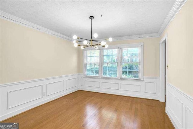 2830 Scottish Mill Way, Marietta, GA 30068 - unfurnished dining area featuring a chandelier, crown molding, a textured ceiling, wainscoting, and wood finished floors