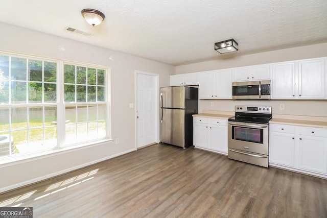 183 Arrowhead Dr, Dallas, GA 30132 - kitchen with stainless steel appliances, wood finished floors, white cabinets, light countertops, and a textured ceiling