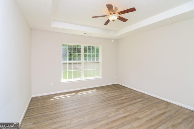 183 Arrowhead Dr, Dallas, GA 30132 - spare room with a tray ceiling, wood finished floors, and ceiling fan