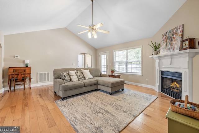 456 Timber Ct, Clarkesville, GA 30523 - living area with lofted ceiling, a glass covered fireplace, arched walkways, and light wood-style flooring