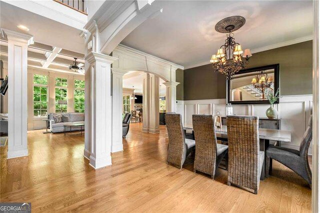 908 Basingstoke Ct, Suwanee, GA 30024 - dining area featuring ornate columns, arched walkways, a decorative wall, ornamental molding, and light wood-style flooring