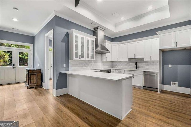 908 Basingstoke Ct, Suwanee, GA 30024 - kitchen featuring wall chimney range hood, crown molding, stainless steel dishwasher, a peninsula, and glass insert cabinets