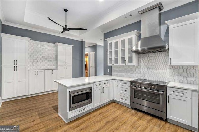 908 Basingstoke Ct, Suwanee, GA 30024 - kitchen featuring stainless steel appliances, wall chimney exhaust hood, ceiling fan, ornamental molding, and white cabinets