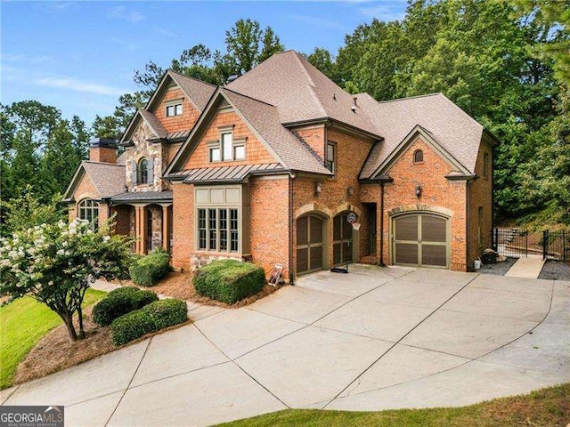 908 Basingstoke Ct, Suwanee, GA 30024 - view of front of home featuring driveway, a standing seam roof, brick siding, stone siding, and an attached garage