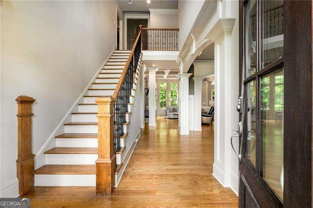 908 Basingstoke Ct, Suwanee, GA 30024 - entrance foyer featuring a towering ceiling, wood finished floors, decorative columns, crown molding, and stairway