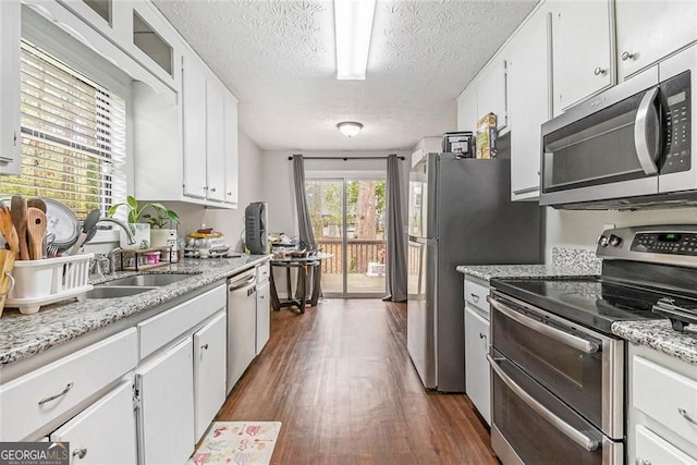 647 Sunshine Trce NW, Acworth, GA 30102 - kitchen featuring stainless steel appliances, dark wood-style flooring, white cabinetry, a textured ceiling, and light stone counters