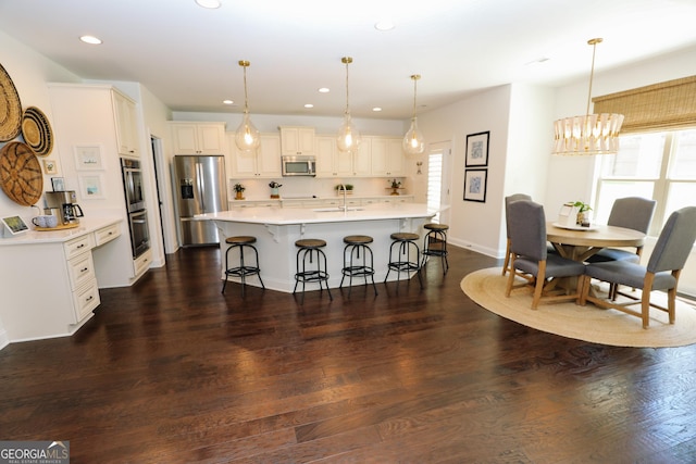 203 Drews Ridge Dr, Newnan, GA 30263 - kitchen with appliances with stainless steel finishes, a kitchen bar, light countertops, recessed lighting, and an island with sink