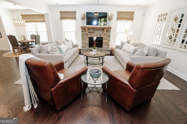 203 Drews Ridge Dr, Newnan, GA 30263 - living area featuring dark wood finished floors, a stone fireplace, and a chandelier