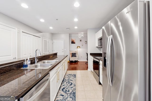 3040 Peachtree Rd NW Unit 702, Atlanta, GA 30305 - kitchen featuring stainless steel appliances, white cabinets, recessed lighting, light tile patterned floors, and dark stone countertops