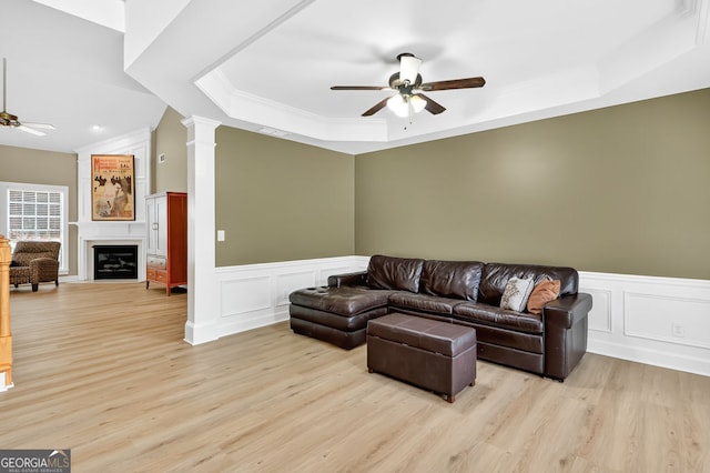 1065 Bookhout Dr, Cumming, GA 30041 - living area featuring a ceiling fan, a tray ceiling, light wood-style floors, a decorative wall, and ornamental molding