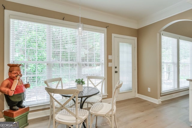 1065 Bookhout Dr, Cumming, GA 30041 - dining area with ornamental molding, healthy amount of natural light, light wood-style flooring, and arched walkways
