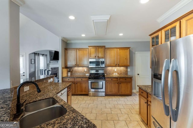 168 Gatlin Ridge Run, Dallas, GA 30157 - kitchen with stainless steel appliances, brown cabinetry, decorative backsplash, glass insert cabinets, and dark stone counters