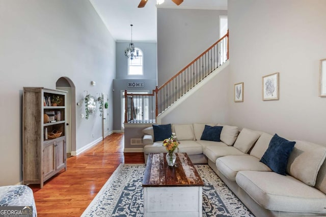 168 Gatlin Ridge Run, Dallas, GA 30157 - living room with a ceiling fan, light wood-style flooring, a towering ceiling, a chandelier, and stairs