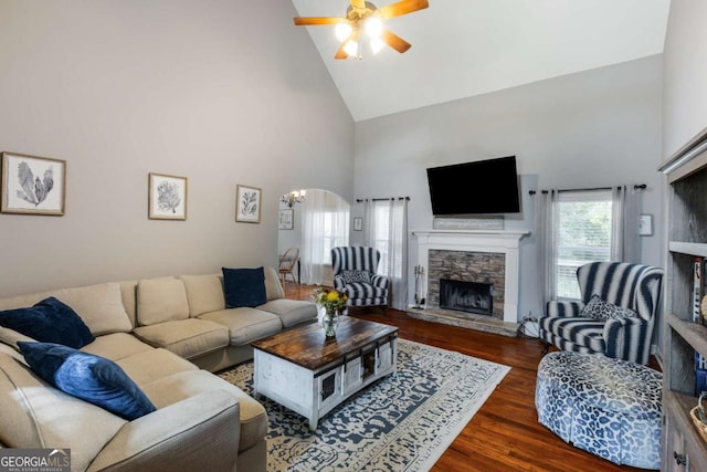 168 Gatlin Ridge Run, Dallas, GA 30157 - living room with high vaulted ceiling, a stone fireplace, ceiling fan, wood finished floors, and a chandelier