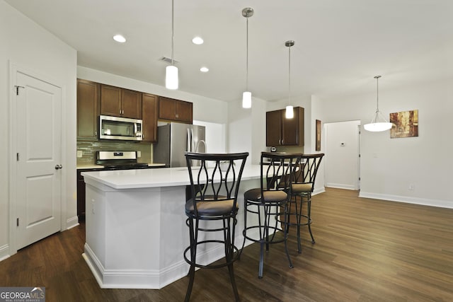 80 Rimmon Ct, Richmond Hill, GA 31324 - kitchen with stainless steel appliances, dark wood finished floors, tasteful backsplash, light countertops, and dark brown cabinetry