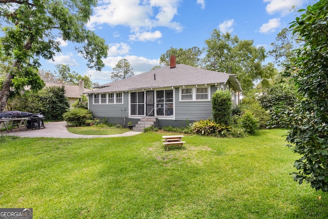 110 College Blvd, Statesboro, GA 30458 - back of property featuring a patio area, a sunroom, a yard, a chimney, and a shingled roof
