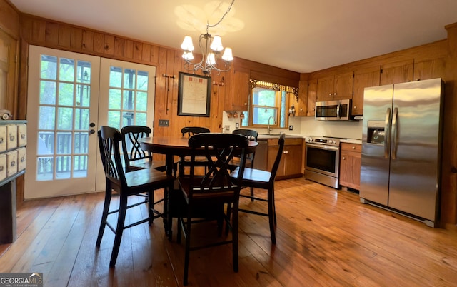 132 Wild Horse Cove Cir, Cleveland, GA 30528 - dining space featuring light wood finished floors, a chandelier, and wood walls