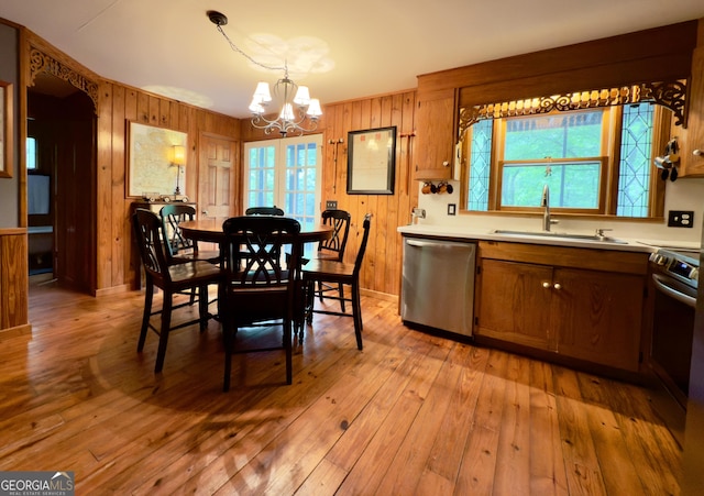132 Wild Horse Cove Cir, Cleveland, GA 30528 - kitchen featuring appliances with stainless steel finishes, a chandelier, wooden walls, light countertops, and light wood-style flooring
