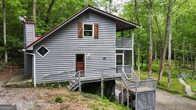 132 Wild Horse Cove Cir, Cleveland, GA 30528 - back of house with a balcony, a chimney, a wooden deck, and a wooded view