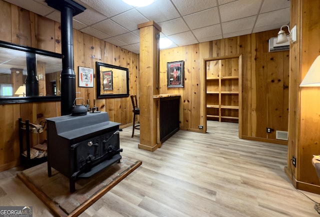 132 Wild Horse Cove Cir, Cleveland, GA 30528 - interior space with a wood stove, wood walls, light wood-style flooring, and a paneled ceiling