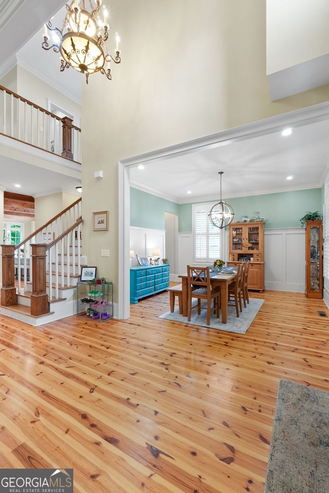 5130 Pratt St SW, Covington, GA 30014 - dining room with a chandelier, wood-type flooring, a towering ceiling, stairs, and crown molding