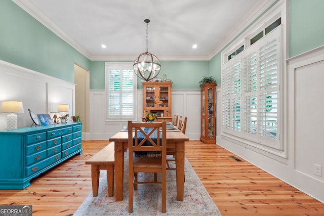 5130 Pratt St SW, Covington, GA 30014 - dining area featuring a decorative wall, a chandelier, ornamental molding, light wood finished floors, and wainscoting