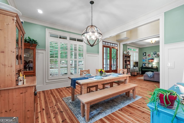 5130 Pratt St SW, Covington, GA 30014 - dining room featuring crown molding, a decorative wall, a chandelier, light wood finished floors, and a wainscoted wall