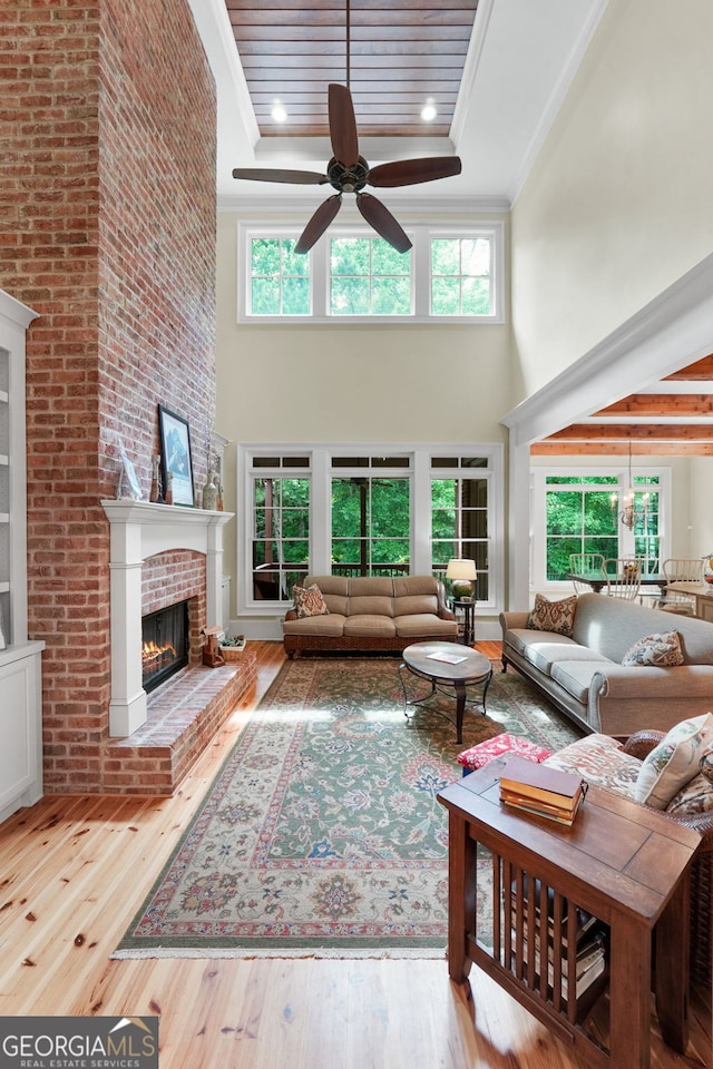 5130 Pratt St SW, Covington, GA 30014 - living area with a towering ceiling, a fireplace, ceiling fan, wood-type flooring, and ornamental molding