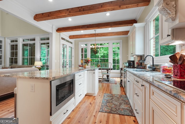 5130 Pratt St SW, Covington, GA 30014 - kitchen with stainless steel microwave, recessed lighting, light wood-type flooring, healthy amount of natural light, and beamed ceiling