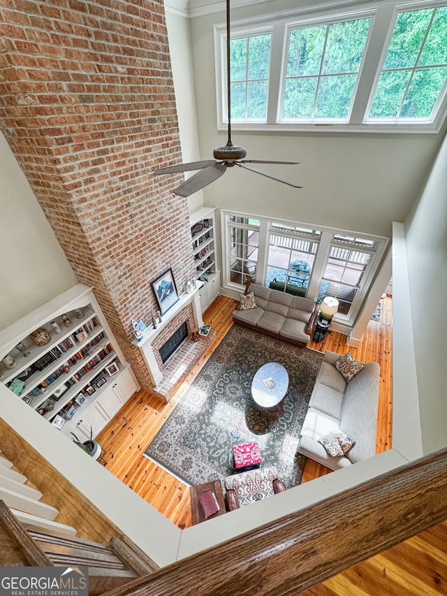 5130 Pratt St SW, Covington, GA 30014 - living area featuring a towering ceiling, hardwood / wood-style floors, a ceiling fan, and a fireplace