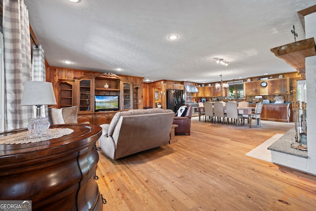 2296 Athens Rd, Royston, GA 30662 - living room featuring light wood-type flooring, a chandelier, and a textured ceiling