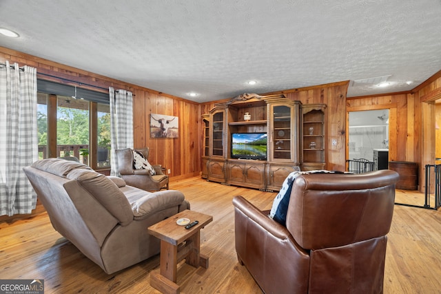 2296 Athens Rd, Royston, GA 30662 - living room featuring wood walls, a textured ceiling, and light wood-style floors
