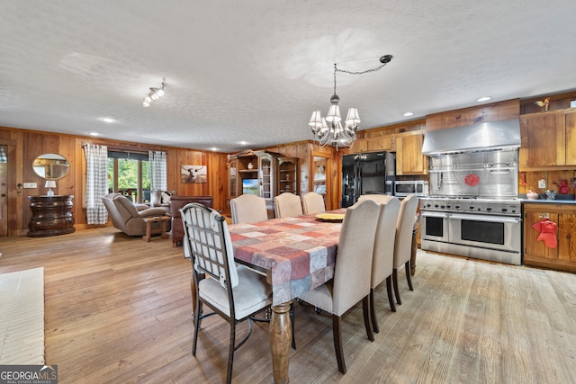 2296 Athens Rd, Royston, GA 30662 - dining area featuring a chandelier, light wood-style flooring, a textured ceiling, wooden walls, and recessed lighting